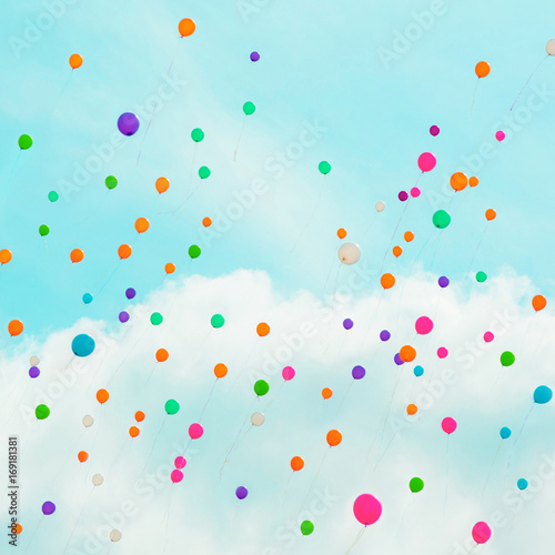 Background with multicolored flying balloons in blue sky