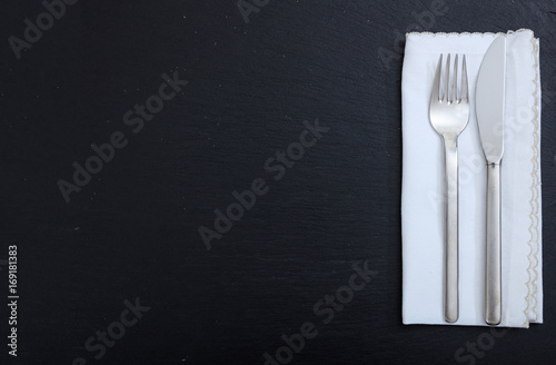 Cutlery and napkin on black background