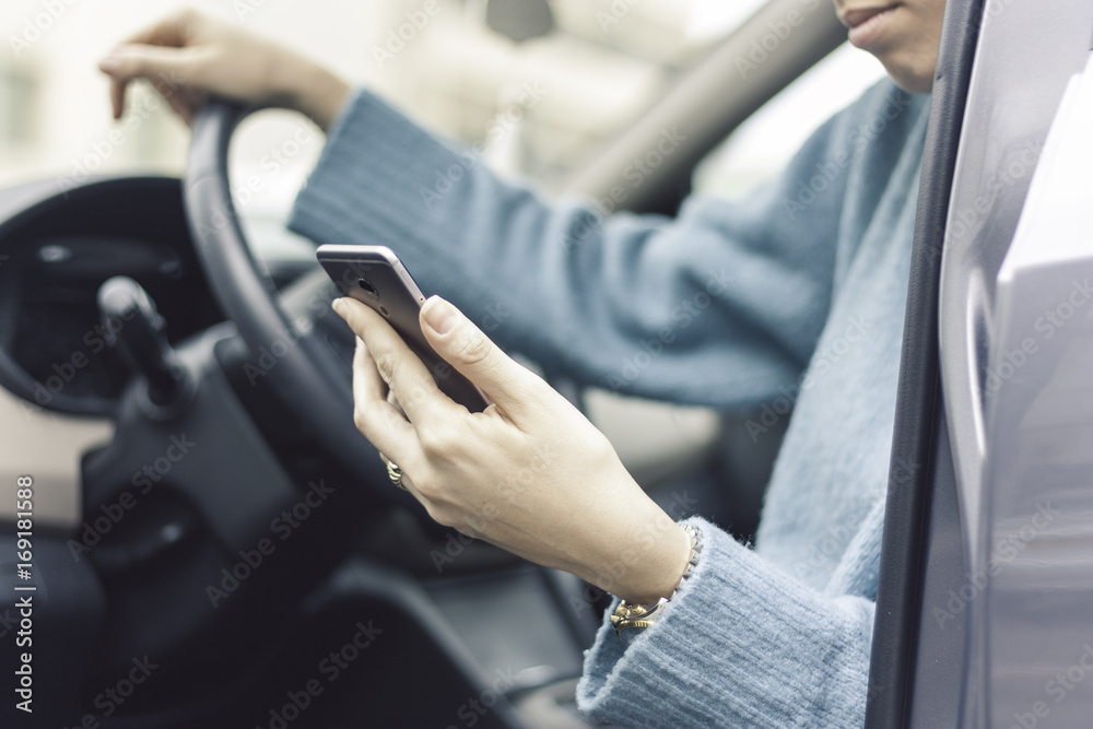 Woman using a cellphone while sitting in a car