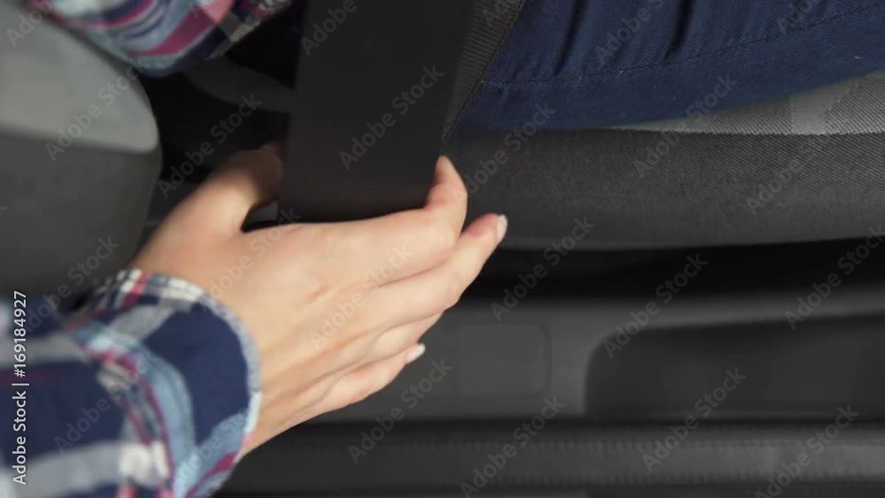 A woman fastens her seat belt in the car A woman fastens her seat belt in the car