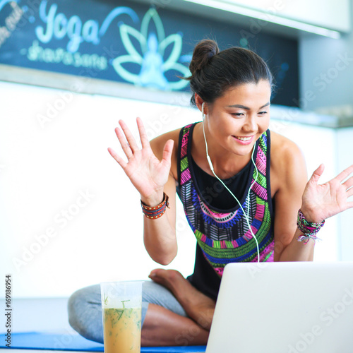 Sporty smiling woman using laptop in bright room. Woman. Lifesty photo