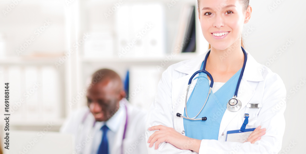 A smiling female doctor with a folder in uniform indoors A smiling female doctor with a folder in uniform indoors