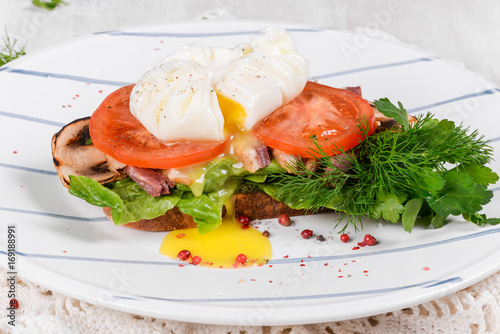 Poached egg with grilled tomatoes, mushrooms and salad leaves.