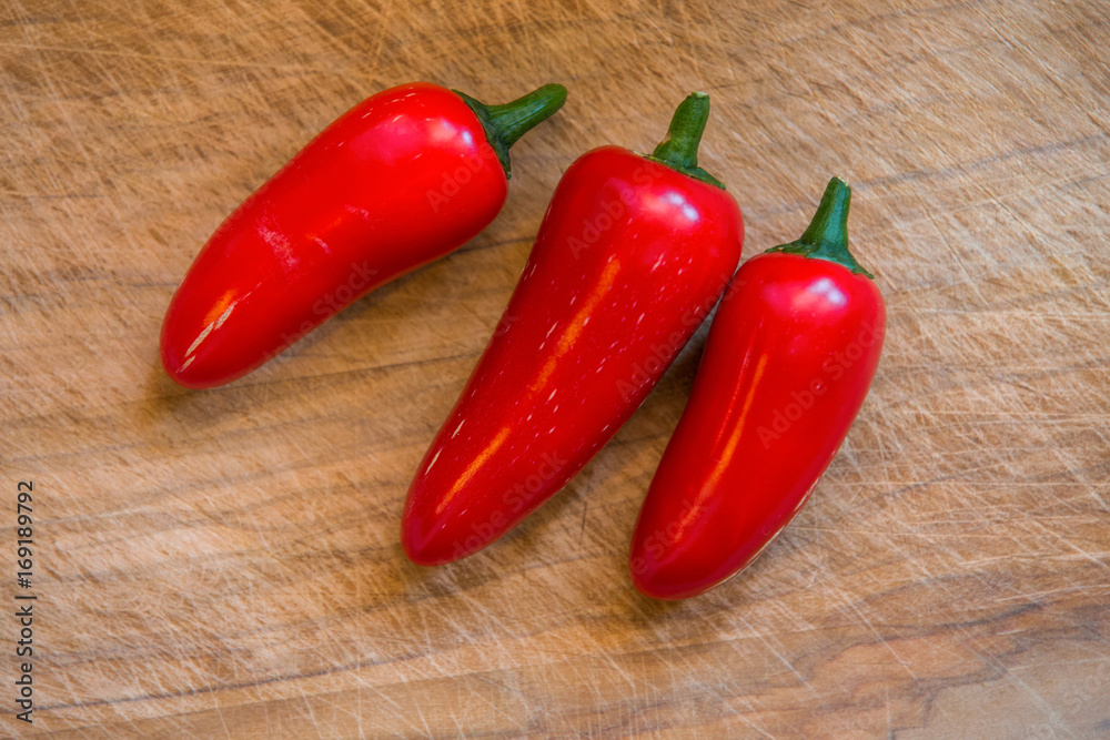 Red Chilies on wooden background 