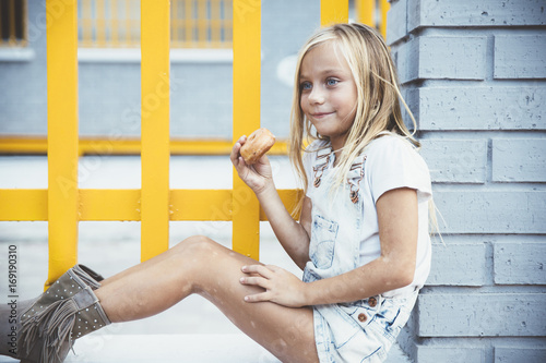 Girl eating donnut outside photo