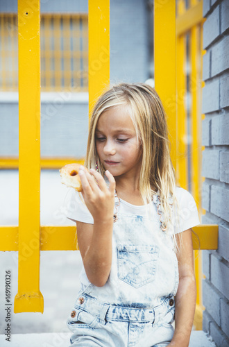 Girl eating donnut outside photo