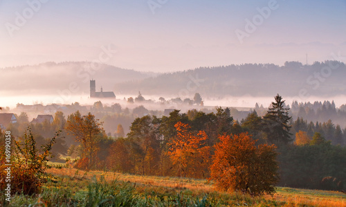 Fototapeta Naklejka Na Ścianę i Meble -  Tower of rural church in misty autumn morning.
