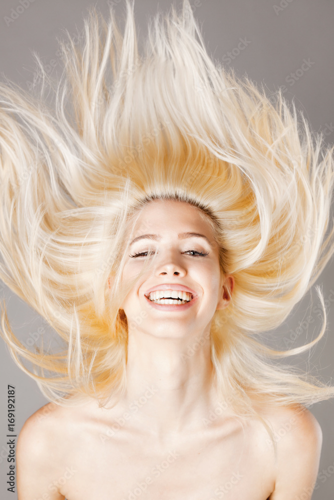 blond girl smiling with hair in the air blond girl smiling with hair in the air
