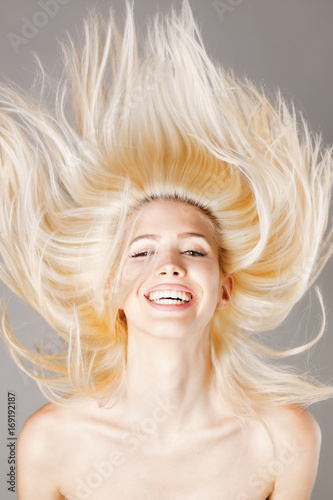 blond girl smiling with hair in the air
