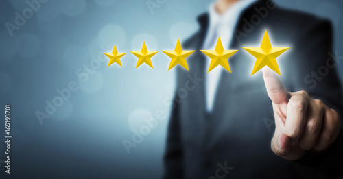 Quadro em tela Businessman pointing five star symbol to increase rating of company