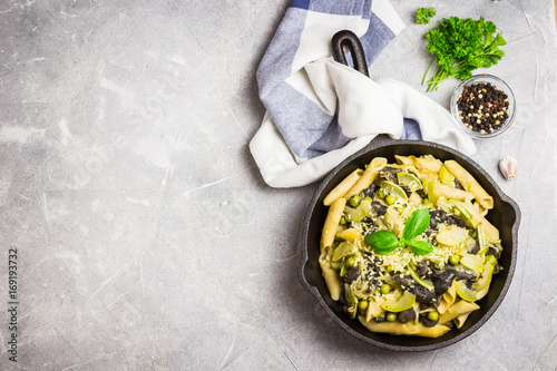 Creamy zucchini, mushroom and peas pasta in cast iron skillet. photo