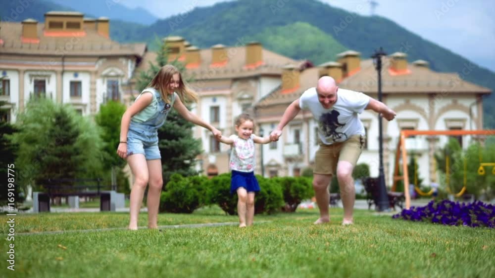 Happy family playing fun on green grass in summer. Happy family playing fun on green grass in summer.