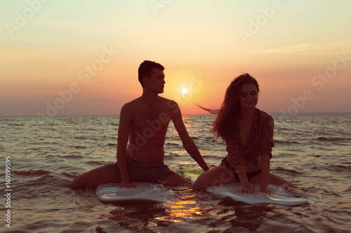 Surfing couple leaning on surfboards in sea © fotofabrika