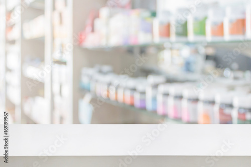 Fototapeta Naklejka Na Ścianę i Meble -  pharmacy store counter table top with blur medicine on shelves