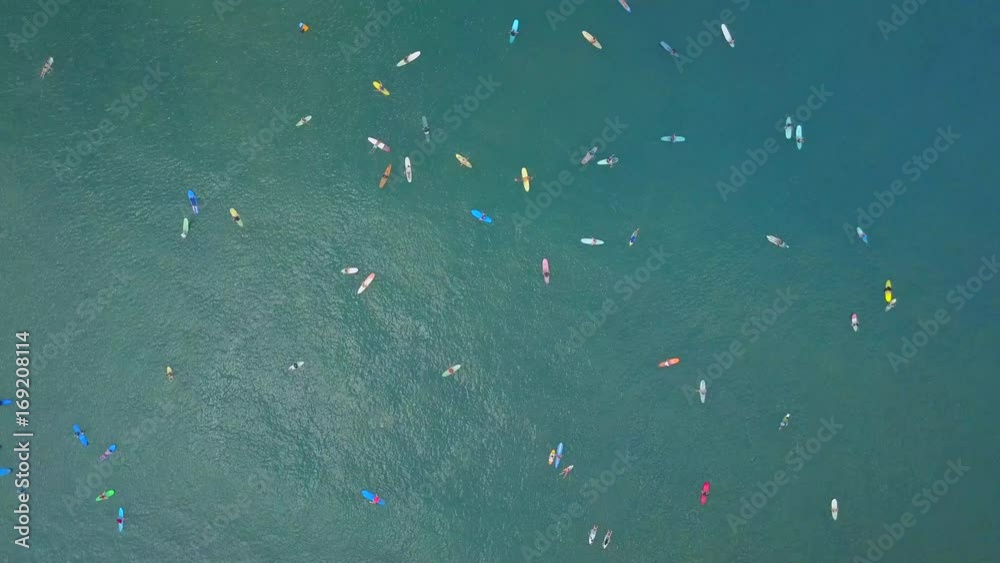 AERIAL TOP DOWN: Beginners surfers learning to surf with big surfboards and longboards at sunny Canggu surfspot. Crowds of surfers in the ocean catching breaking waves in dreamy sunny Bali island AERIAL TOP DOWN: Beginners surfers learning to surf with big surfboards and longboards at sunny Canggu surfspot. Crowds of surfers in the ocean catching breaking waves in dreamy sunny Bali island