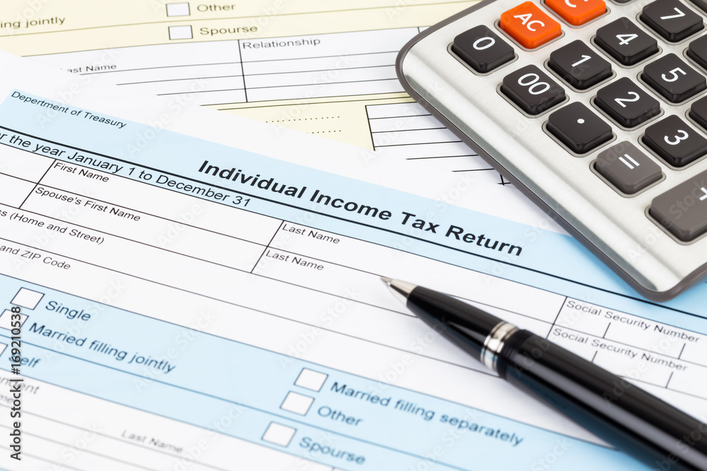 Tax form with pen and calculator; document are mock-up Tax form with pen and calculator; document are mock-up