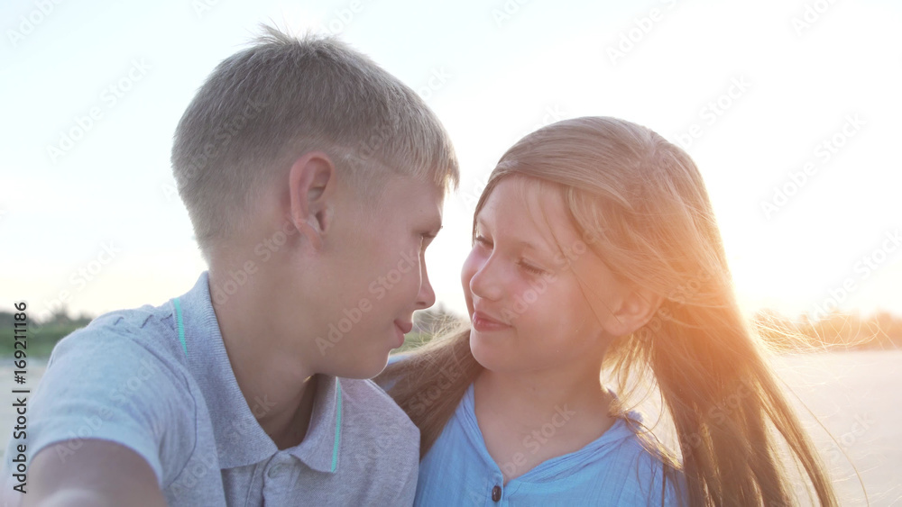 Closeup of blonde little brother and sister taking selfie together