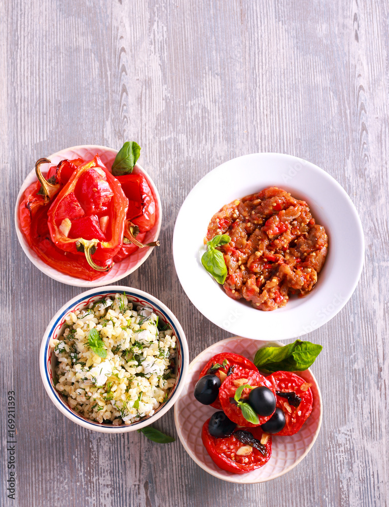 Variety of salads and appetizers on plates Variety of salads and appetizers on plates