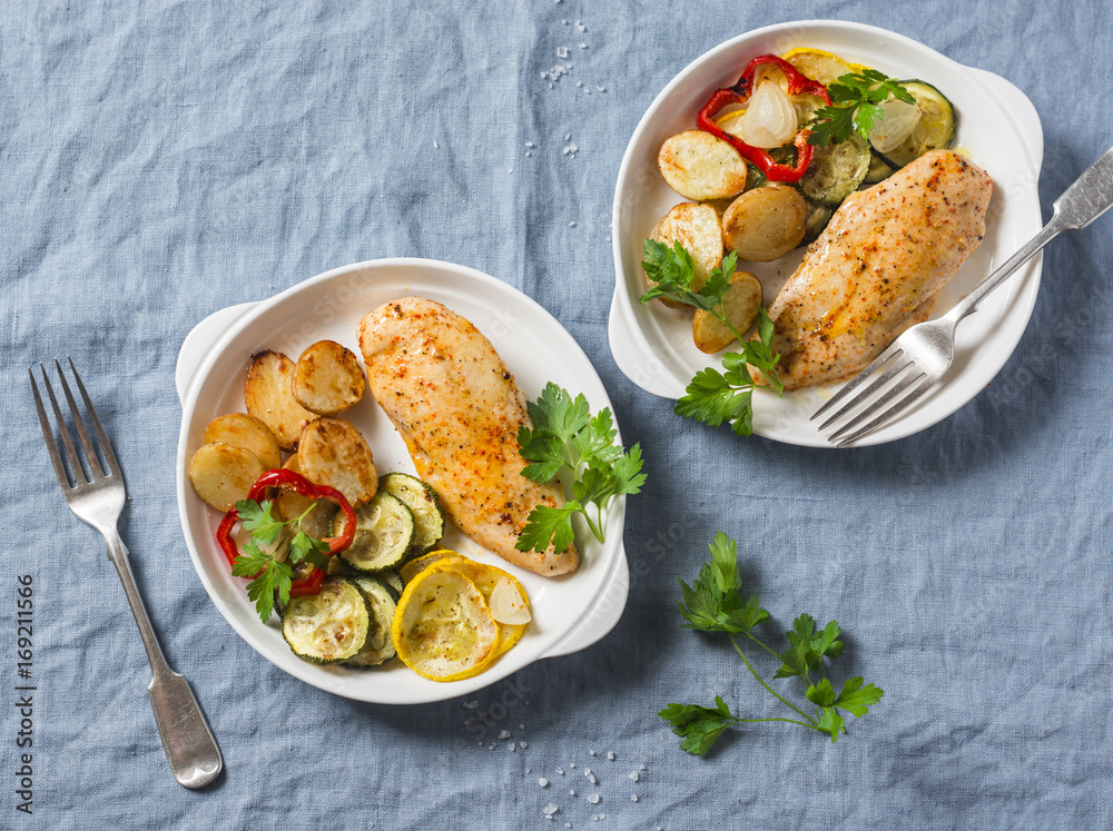 Roasted chicken provencal with zucchini, squash, potatoes. Delicious healthy lunch on a blue background, top view Roasted chicken provencal with zucchini, squash, potatoes. Delicious healthy lunch on a blue background, top view