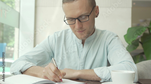 Businessman writing a to do list in a business planner