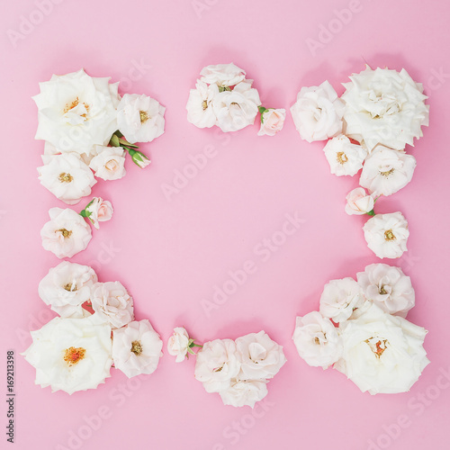 Frame made of white roses on pink background. Flat lay, top view. Flower background. Frame of flowers. Flowers frame wreath