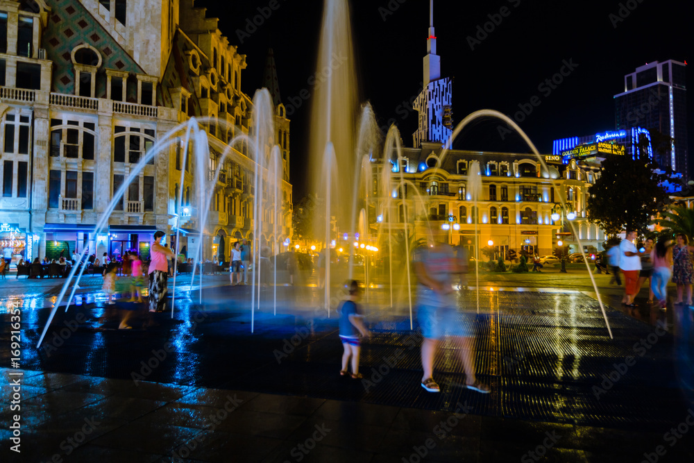 people looking at Fountain with night light