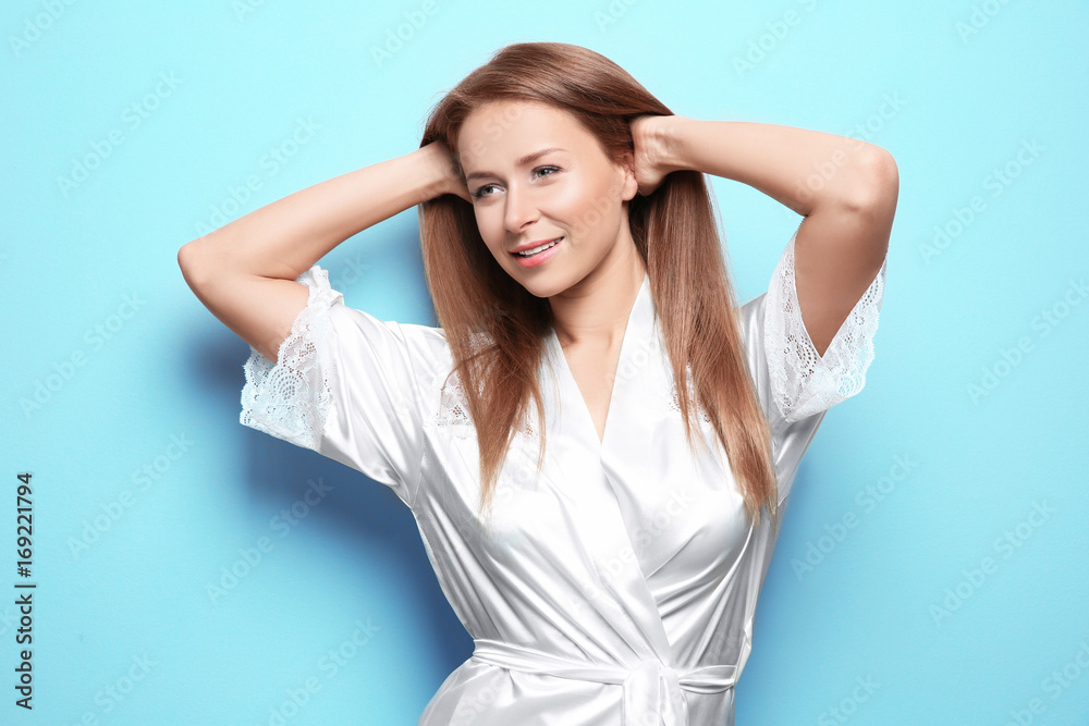 Beautiful young woman after shower in silk bathrobe on light background Beautiful young woman after shower in silk bathrobe on light background