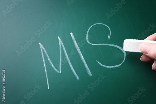 Female hand writing management abbreviation MIS on chalk board
