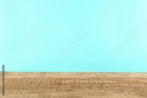 Wooden table against mint background
