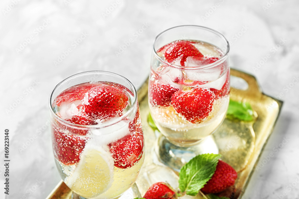 Tray with glasses of delicious strawberry lemonade on light table Tray with glasses of delicious strawberry lemonade on light table