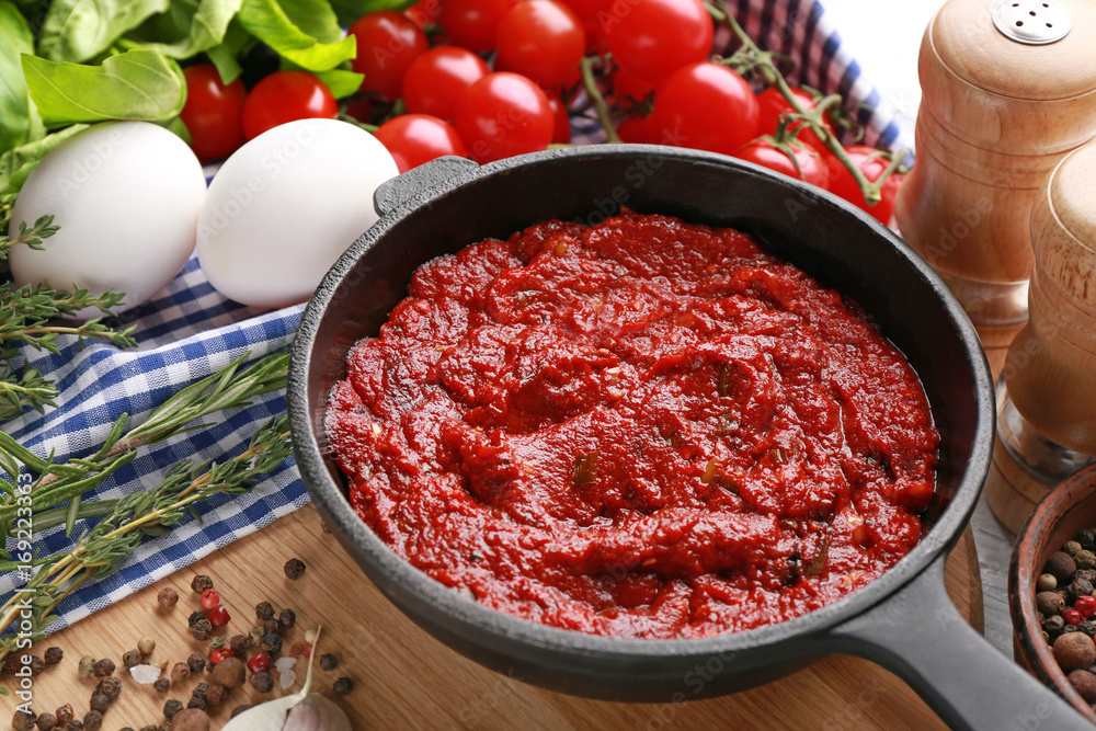 Frying pan with tasty spicy sauce on table Frying pan with tasty spicy sauce on table