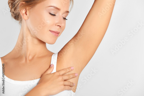 Fototapeta Naklejka Na Ścianę i Meble -  Beautiful young woman on light background. Concept of using deodorant