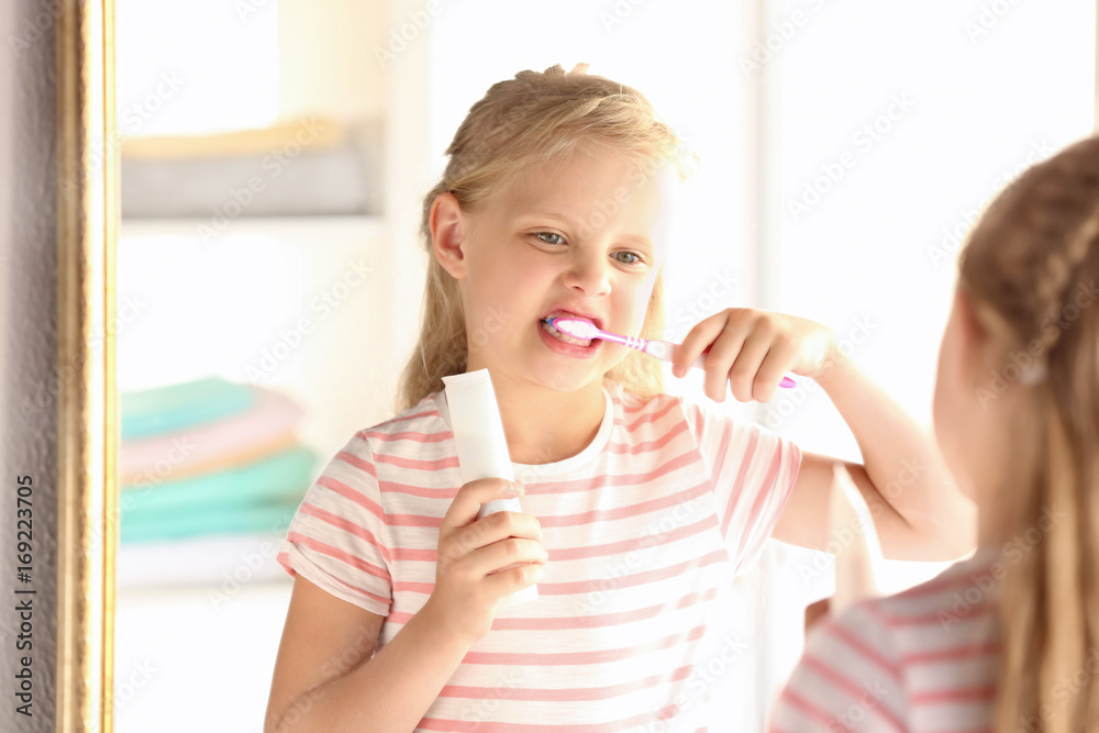 Cute little girl cleaning teeth at home Cute little girl cleaning teeth at home