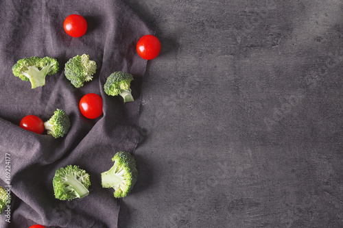 Fresh green broccoli with tomatoes on grey background