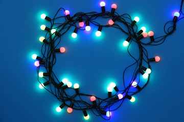 Circle of Christmas lights glowing on blue background