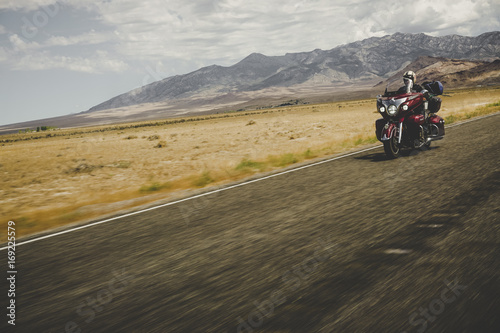 Indian motorcycle traveler on lonely road with mountains