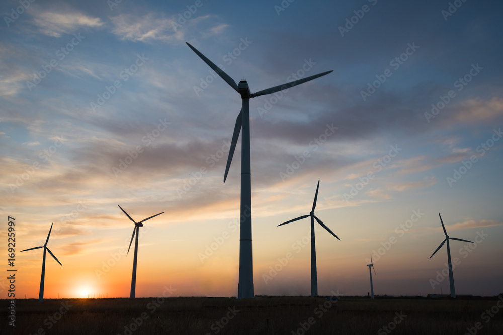 Power generators of windmills at sunset of the day Power generators of windmills at sunset of the day
