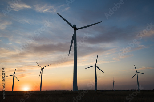 Power generators of windmills at sunset of the day