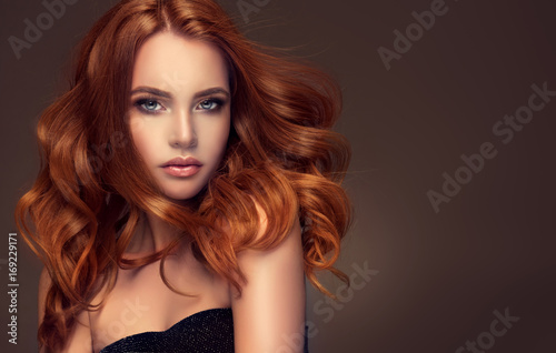 Beautiful model girl with long red curly hair .Red head . Care products ,hair colouring .