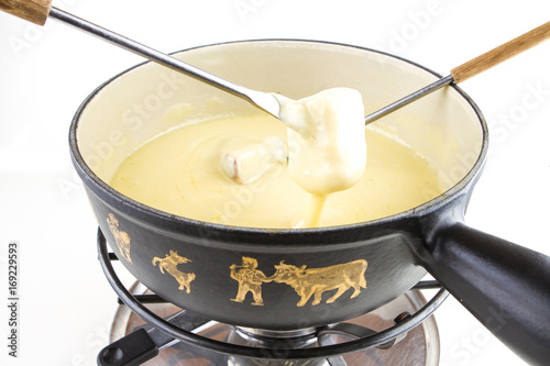 SWISS CHEESE FONDUE WITH BREAD, FORK AND POT ON WHITE BACKGROUND