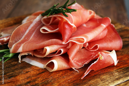 Italian prosciutto crudo or jamon with rosemary. Raw ham. photo