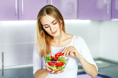  Young happy girl eating vegetable spring salad. The concept is healthy food, diet, vegetarianism, weight loss.