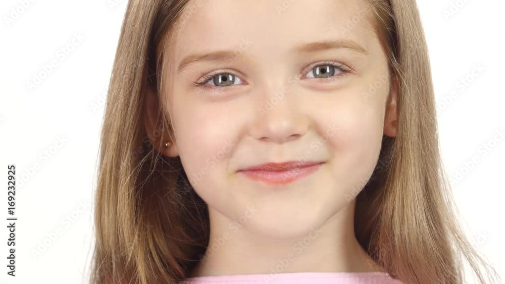 Little girl genuinely smile at the camera. White background. Close up Little girl genuinely smile at the camera. White background. Close up