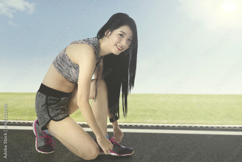 Female runner tying shoelaces Female runner tying shoelaces