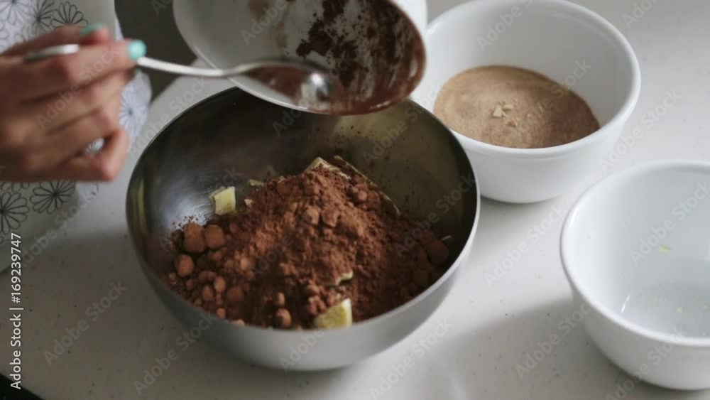 Woman adding ingredients to a bowl for cooking home made chocolate