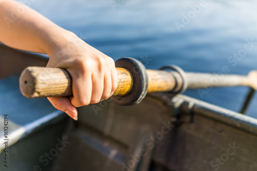 Canvastavla Female hand on row boat oar closeup in summer with water
