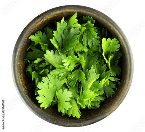 Top view of fresh parsley leaves in bowl on white background photo