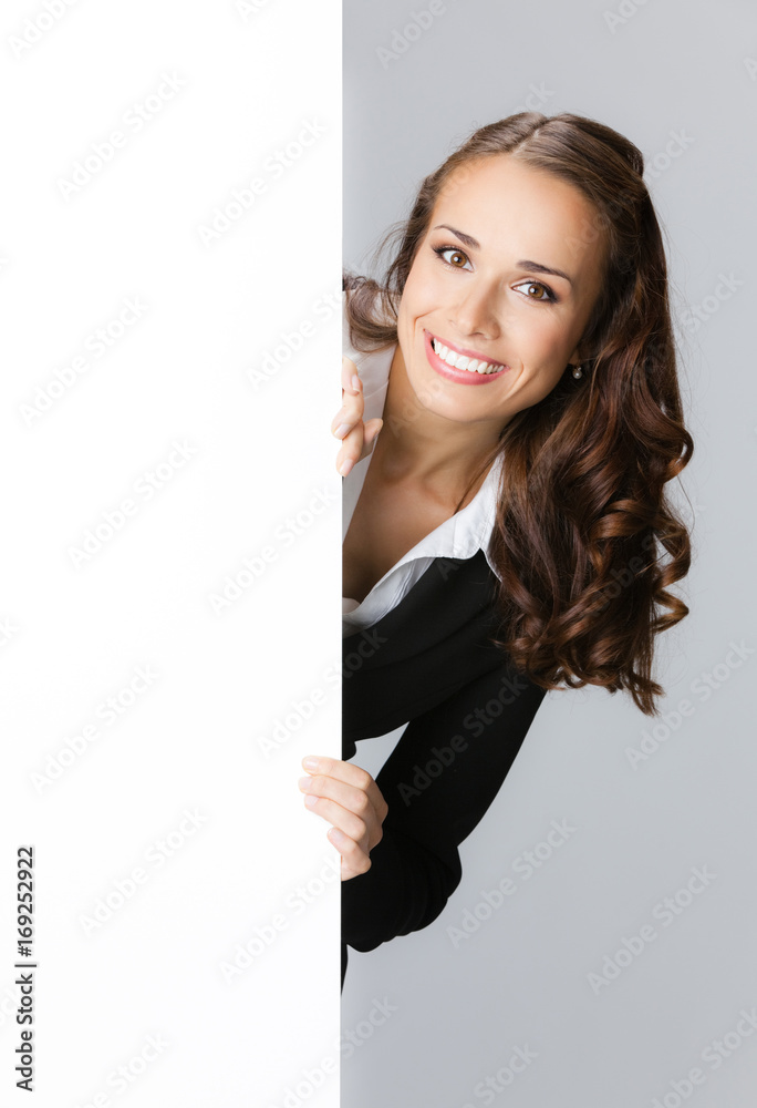 Businesswoman showing signboard, over grey