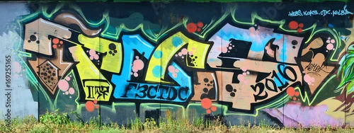 Obraz Stara ściana, pomalowana w kolorowe graffiti, rysowana farbami w aerozolu. Obraz w tle na temat rysowania graffiti i sztuki ulicznej