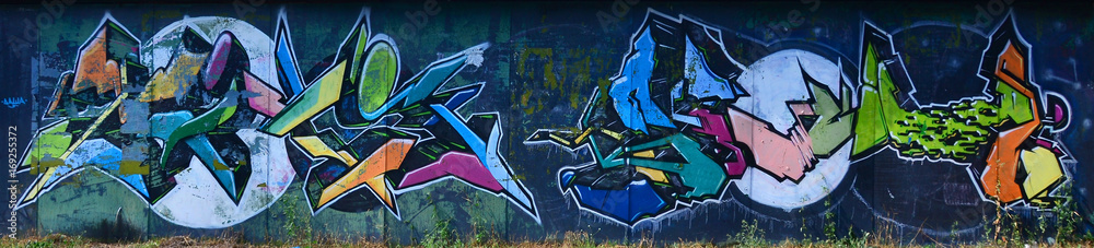 The old wall, painted in color graffiti drawing with aerosol paints. Background image on the theme of drawing graffiti and street art